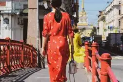 woman in red and white polka dot robe walking on sidewalk during daytime