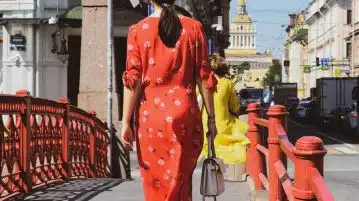 woman in red and white polka dot robe walking on sidewalk during daytime