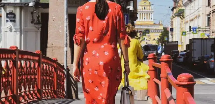 woman in red and white polka dot robe walking on sidewalk during daytime