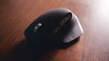 black cordless computer mouse on brown wooden table