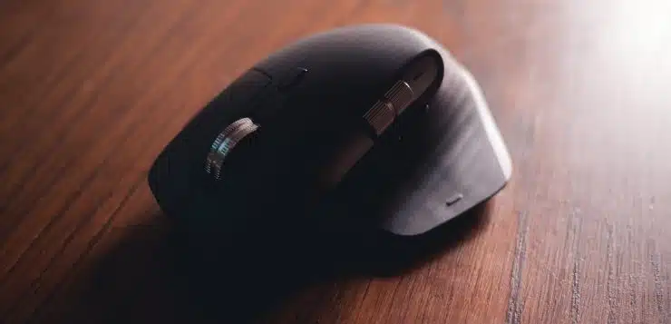 black cordless computer mouse on brown wooden table